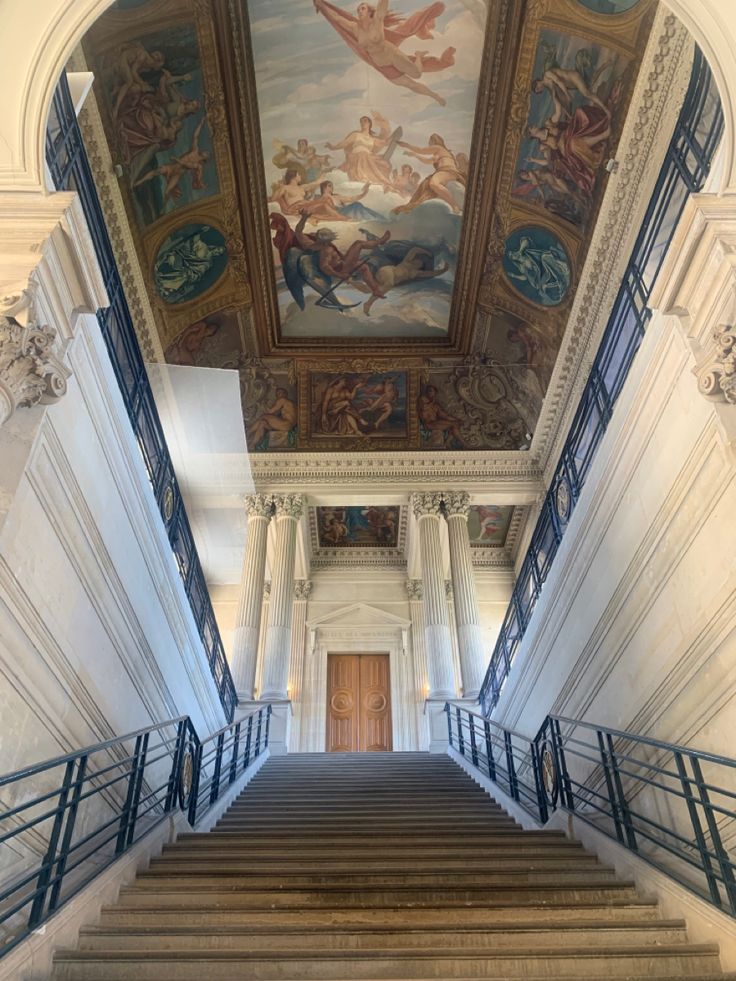 an ornate staircase with paintings on the ceiling