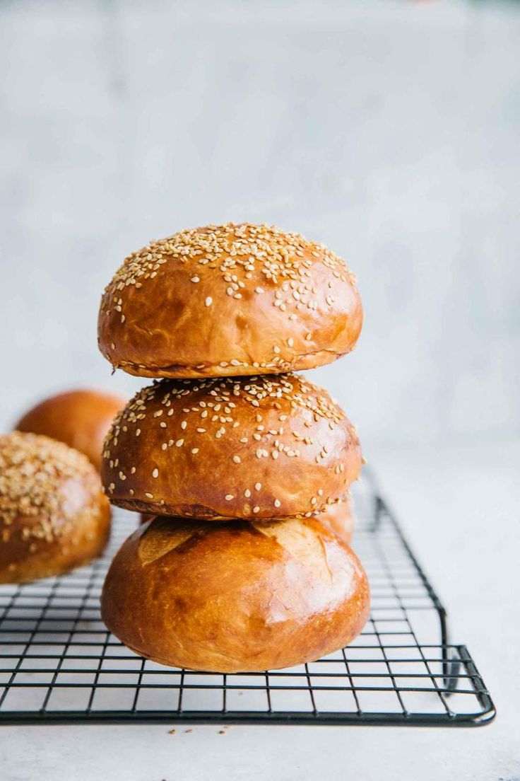 three bagels stacked on top of each other on a cooling rack with sesame seeds