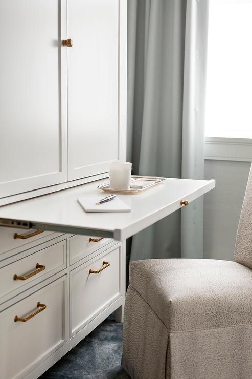 a white desk and chair in front of a window with curtains on the windowsill