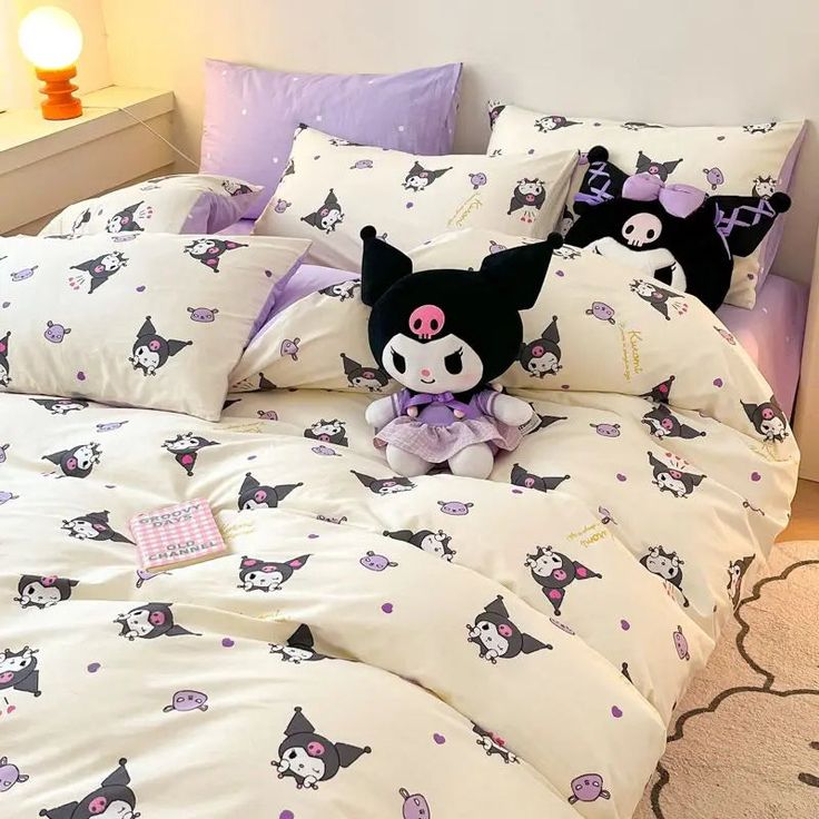 a stuffed animal sitting on top of a bed covered in white and purple comforters