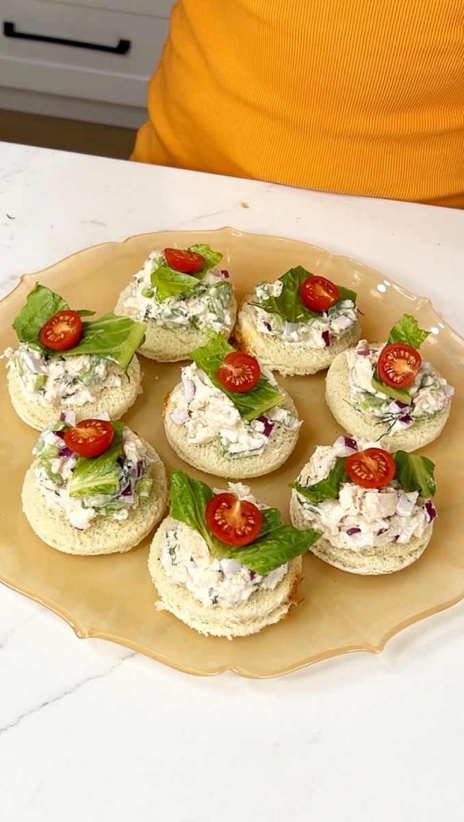 small appetizers are arranged on a plate with lettuce, tomatoes and cheese