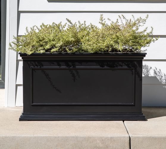 a black planter sitting on the side of a building