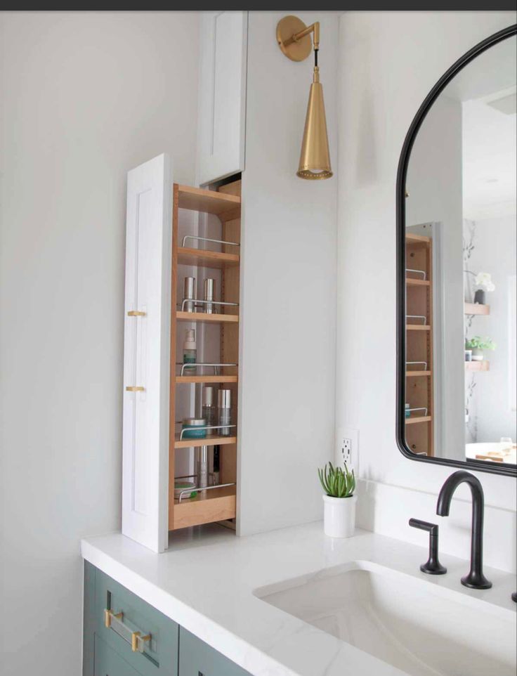 a bathroom with a sink, mirror and shelving unit