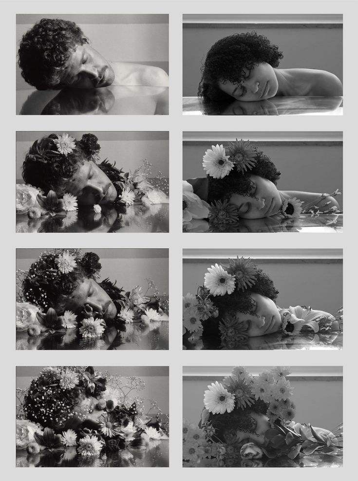 black and white photograph of woman with flowers in her hair laying down on the floor