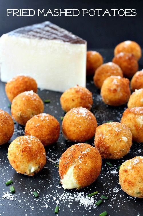 fried mashed potatoes on a black plate with a block of cheese in the background