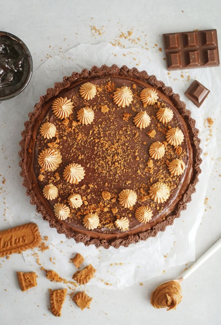 there is a chocolate pie on the table next to some pieces of cake and candy