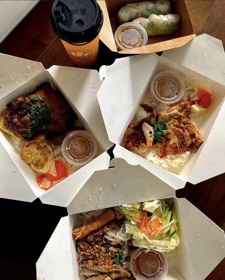 four take out boxes with food in them