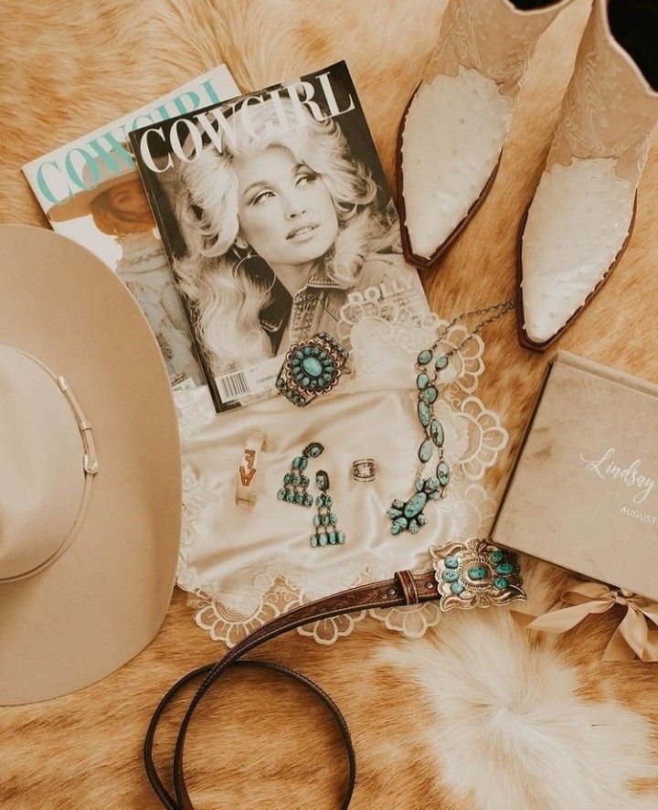 the contents of a woman's purse and hat laid out on a fur surface