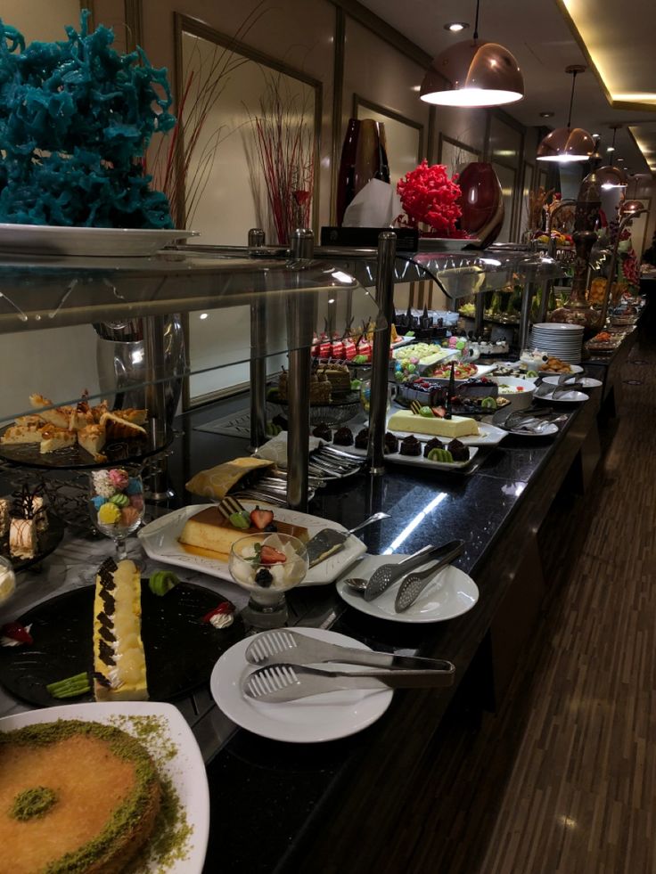 a buffet line with many different types of food on plates and serving utensils