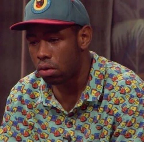 a man wearing a baseball cap sitting down