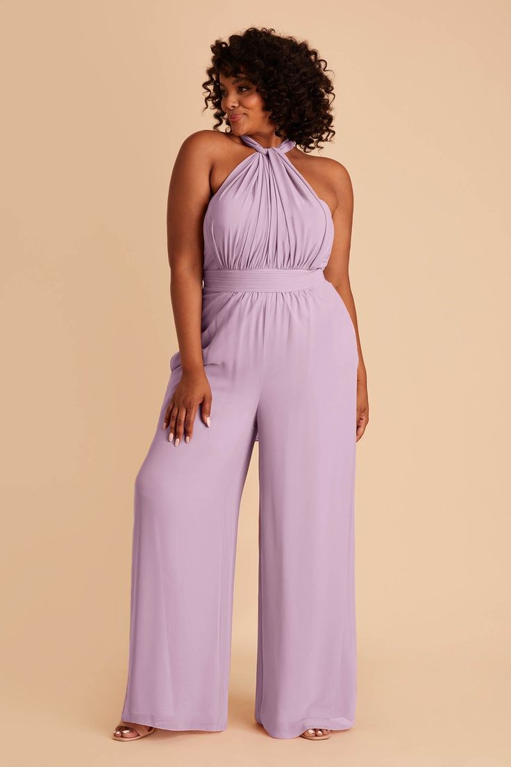 a woman in a purple jumpsuit with her hands on her hips