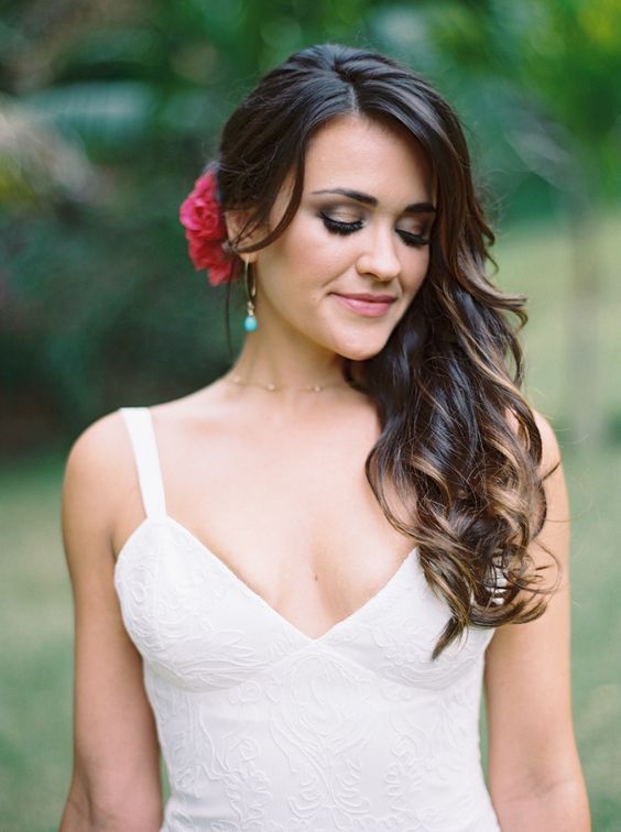 a woman wearing a white dress and flower in her hair