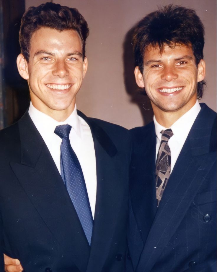 two men in suits are smiling for the camera