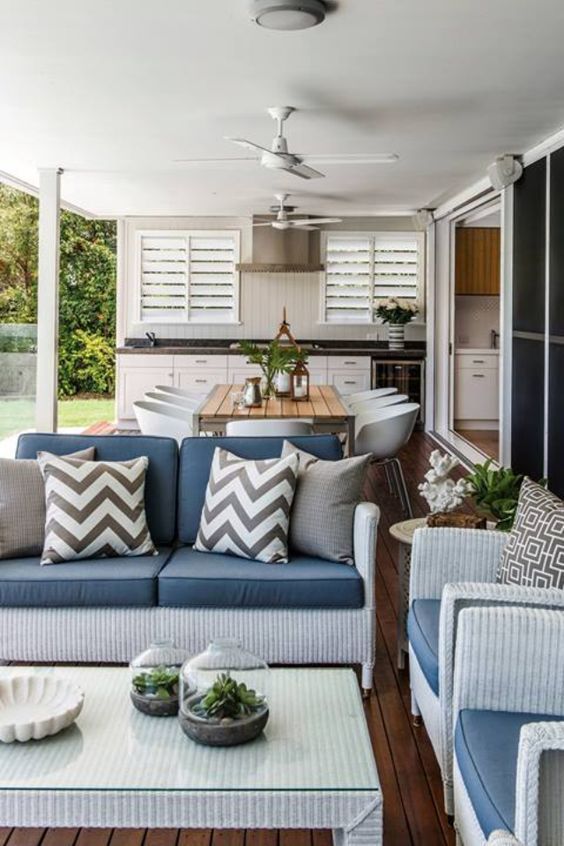 a living room filled with furniture next to a kitchen and dining area on top of a hard wood floor