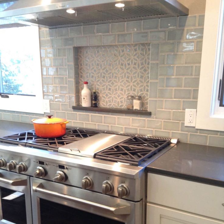 a stove top oven sitting inside of a kitchen next to a counter with an orange bowl on it