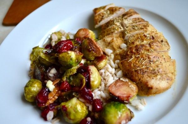 a white plate topped with meat, rice and brussel sprouts