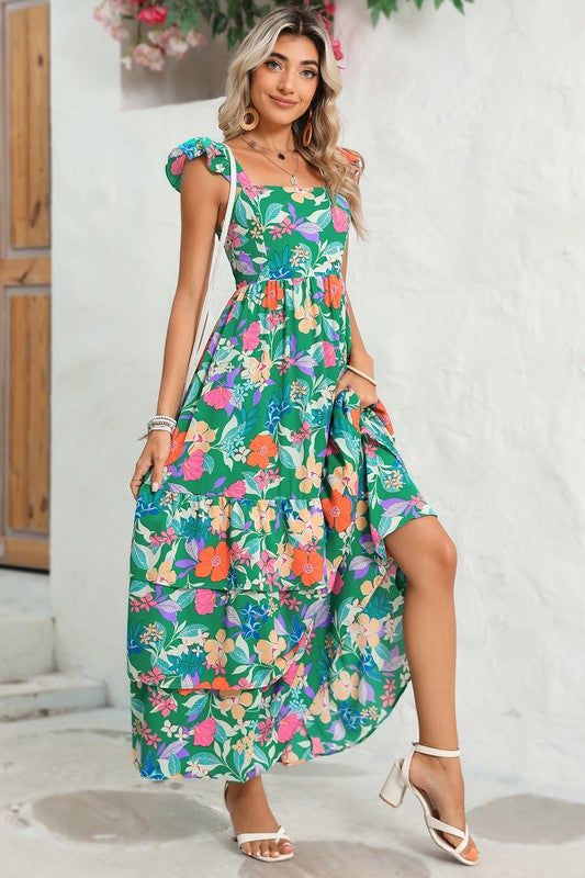 This flowy dress is perfect for warm weather or beach outings. The ruffled shoulder strap adds movement and an extra layer of visual interest. It showcases a vibrant and colorful floral pattern, creating a fresh and summery vibe The high waist design accentuates the curves and creates a feminine silhouette. Wholesale maxi dresses available for bulk orders, great for retailers Fabric Contents: Product Weight: 0.73 kgMaterial: 100%Polyester Printed Square Neck Maxi Dress For Vacation, Green Maxi Sundress For Brunch, Printed Square Neck Maxi Dress For Beach, Square Neck Printed Maxi Dress For Beach, Summer Tropical Print Floral Dress For Garden Party, Summer Floral Dress With Tropical Print For Garden Party, Flowy Square Neck Sundress For Vacation, Casual Floral Dress With Vibrant Print For Brunch, Casual Floral Dress With Vibrant Print For Day Out