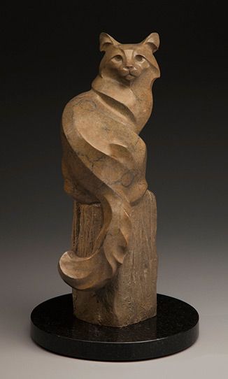 a statue of a cat sitting on top of a piece of wood in front of a black background