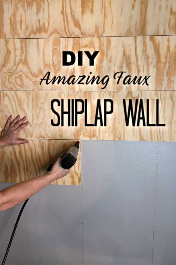 a man using a power drill to paint the side of a wood paneled wall