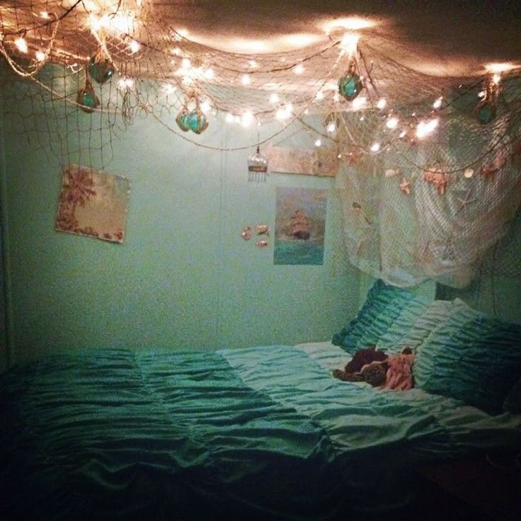 a bedroom with lights strung from the ceiling and a bed in it's corner