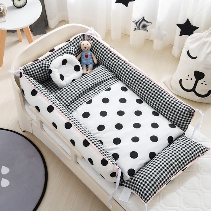 a black and white polka dot crib bed with stuffed animals on the pillow in it