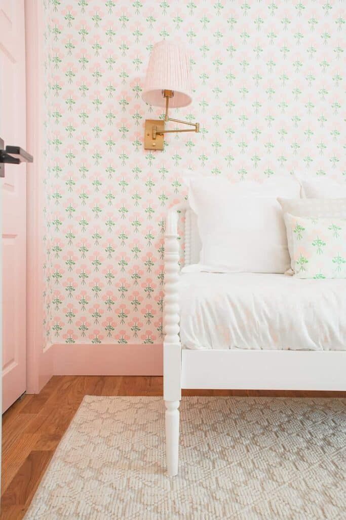 a white bed sitting in a bedroom next to a pink wall