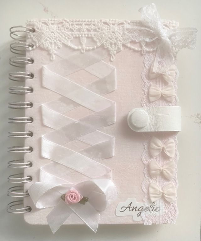 a pink and white book with ribbons on it