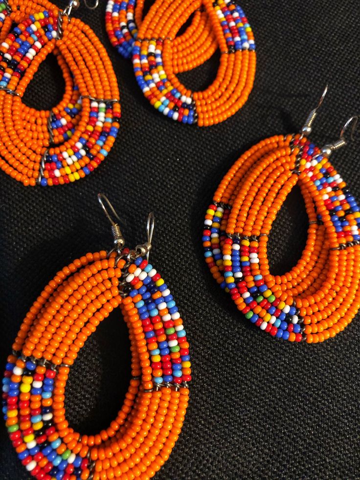 Stand out and make a statement with these stunning colorful tribal style earrings. Traditional Kenya style earrings crafted from seed beads. Pierced. Multi color tribal style beaded earrings. Your purchase empowers women in Kenya to build a sustainable business, alleviate extreme poverty and to support their families with dignity. ******SHIPMENT DE;LAY OF NEW STOCK - AWAITING ARRIVAL OF SEVERAL COLORS - EXPECTED ANYDAY******* Cheap Orange Beaded Earrings For Festival, Multicolor Teardrop Beaded Earrings With Tiny Beads, Multicolor Teardrop Beaded Earrings With Large Beads, Orange Beaded Drop Earrings For Festival, Orange Teardrop Beaded Earrings With Ear Wire, Orange Teardrop Beaded Earrings With Dangling Beads, Handmade Orange Teardrop Beaded Earrings, Multicolor Large Beaded Teardrop Earrings, Orange Teardrop Jewelry With Colorful Beads