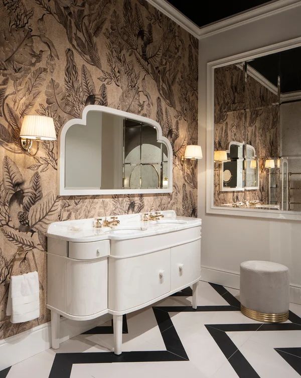 a bathroom with black and white tile flooring and wallpaper, two mirrors on the wall