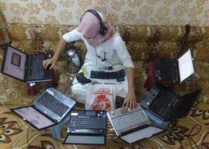 a person sitting on a couch with several laptops