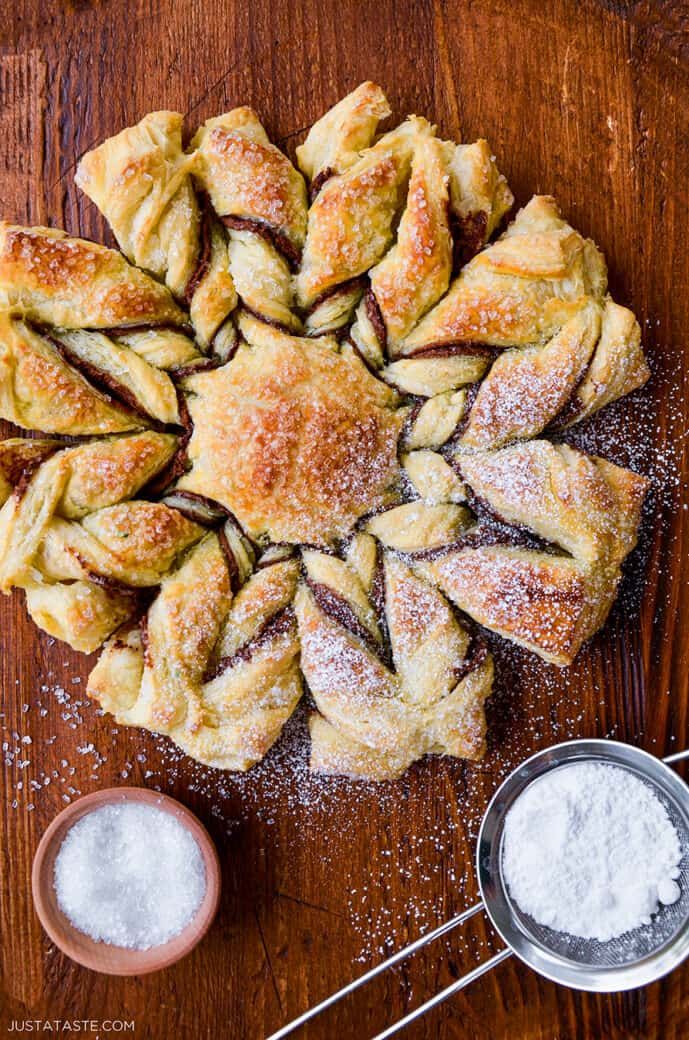 several pastries on a wooden table with powdered sugar