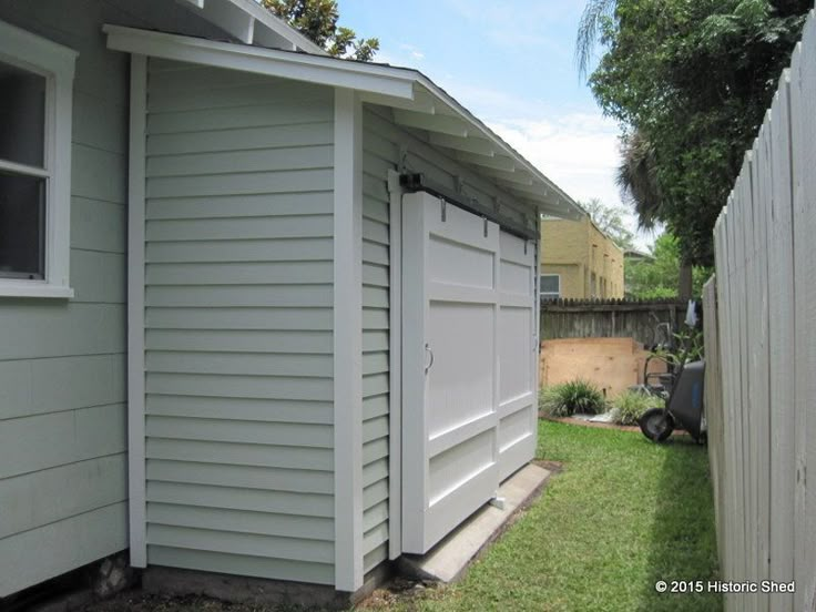 the back side of a house with two garages and a yard in front of it