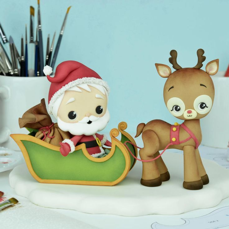 a christmas cake with a reindeer and santa clause riding in a sleigh