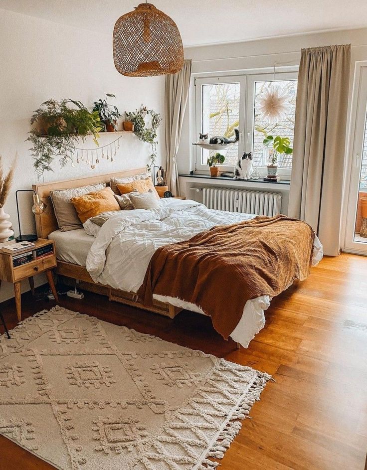 a bedroom with a bed, rug and plants in the window sill on the wall