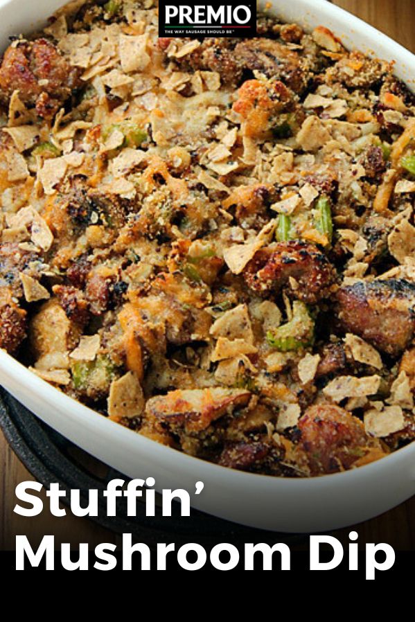 a casserole dish with stuffing in it on top of a wooden table next to a fork