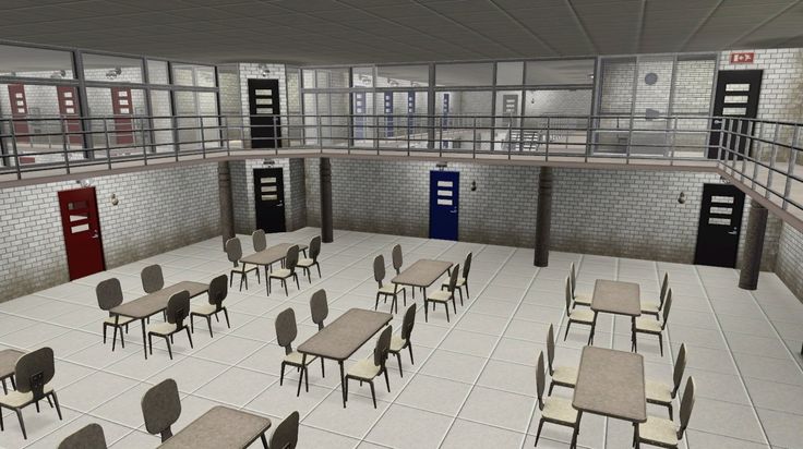 an empty classroom with tables and chairs in the middle, surrounded by metal railings