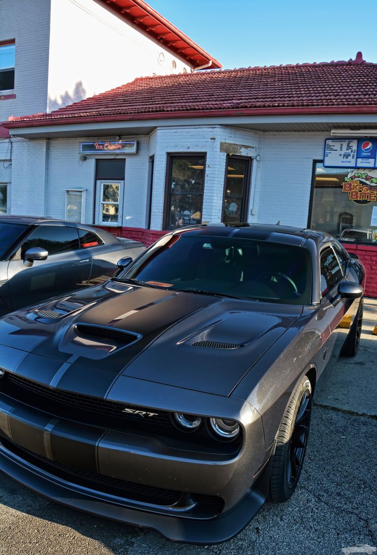 a car parked in front of a building next to other cars on the side of the road