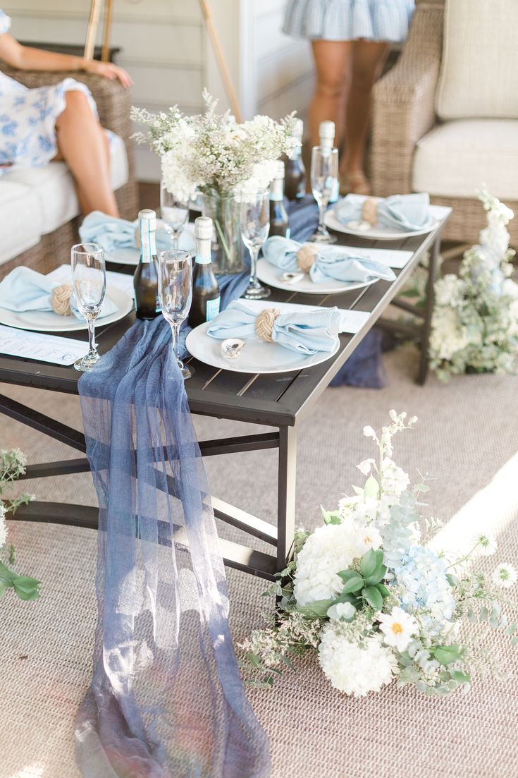 the table is set with blue and white flowers