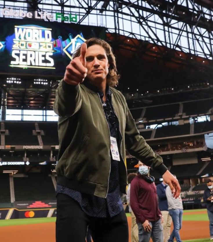 a man giving the thumbs up sign at a baseball game