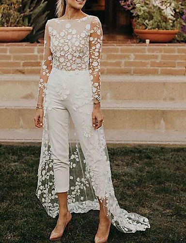 a woman standing in the grass wearing a white outfit