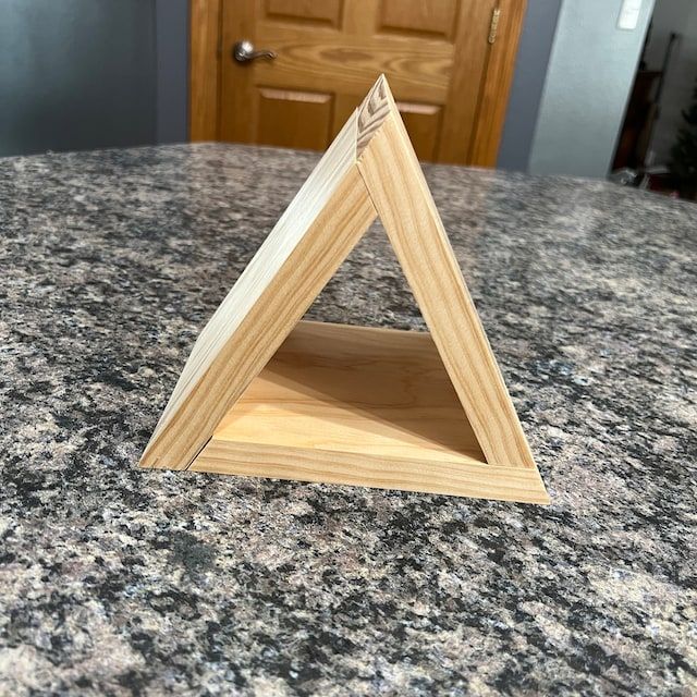 a wooden triangle sitting on top of a counter