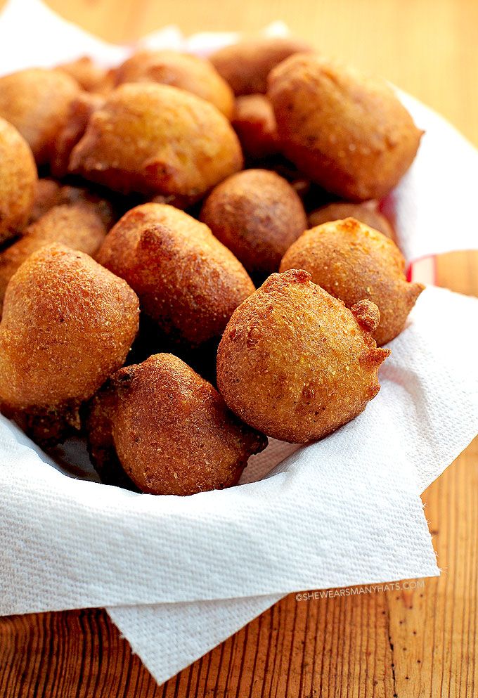 a basket filled with fried food sitting on top of a wooden table next to a napkin