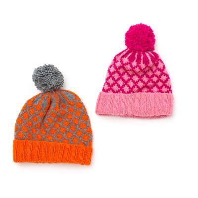 two knitted hats with pom - poms on them, one orange and the other pink