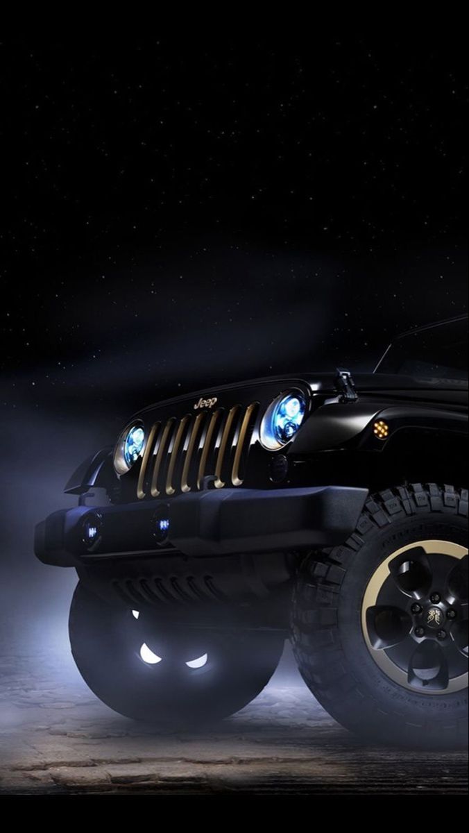 a black jeep parked in the dark with its lights on