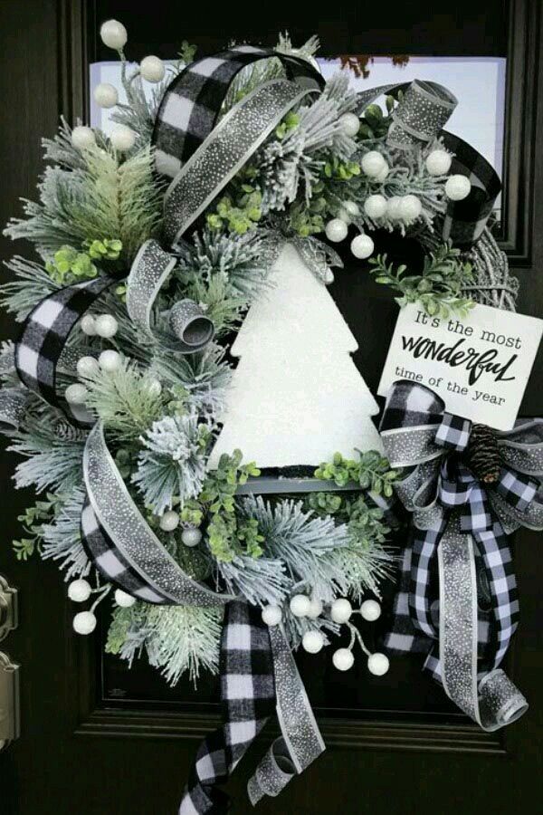 a christmas wreath on the front door with a sign that says it's the most wonderful