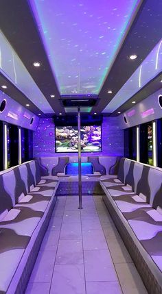 the inside of a bus that is lit up with purple lights and white seats on both sides