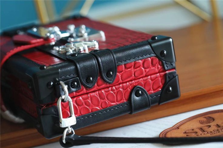 Nicolas Ghesquière reimagined the iconic fittings of historic House trunks to create the Petite Malle handbag. In precious crocodilian leather, this covetable “little trunk” travels elegantly from day into night. Detailed Features 20 x 12.5 x 5 cm (Length x height x width ) Rubis Red Brilliant Alligator leather Brilliant Alligator-leather trim Sheepskin lining Malletage printed lining Silver-color hardware Iconic S-lock clasp Magnetic closure Strap: Removable, adjustable Strap Drop: 50.0 cm Stra Louis Vuitton Petite Malle, Travel Trunk, Lady Bags, Branded Handbags, Luxury Accessories, Historic Homes, Christmas Sale, Grade 1, Exclusive Collection