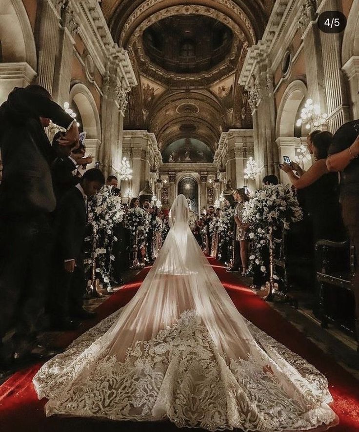 the bride is walking down the aisle in her wedding dress