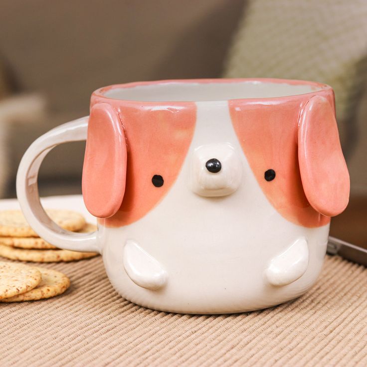 a dog mug sitting on top of a table next to crackers