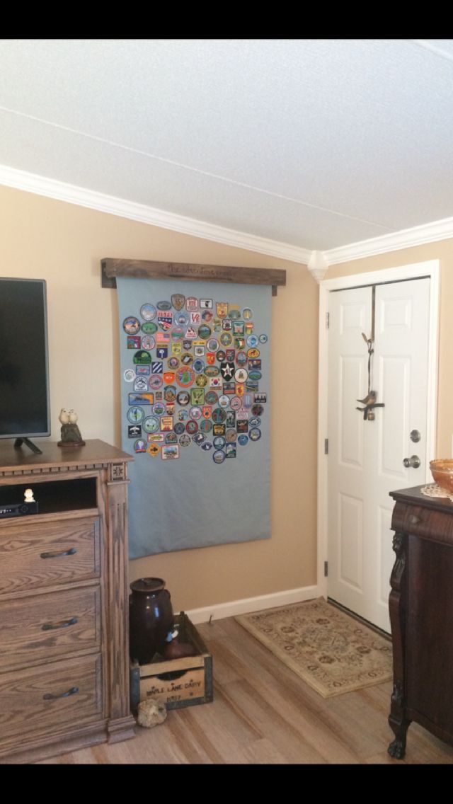 a room with a dresser, television and large tapestry hanging on the wall in it